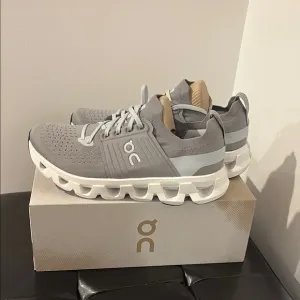 On Running Gray and White Athletic Shoes with Cloud Pods